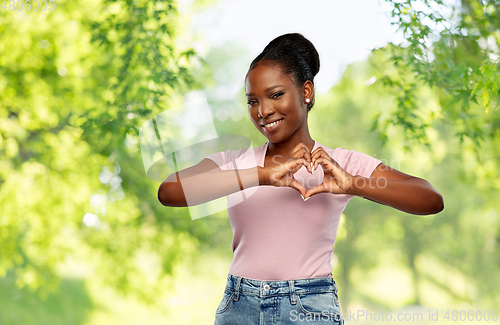 Image of african american woman making hand heart gesture