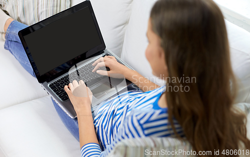 Image of close up of teenage girl typing on laptop at home