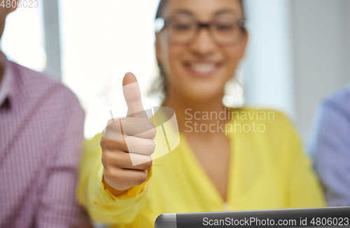 Image of happy young woman with tablet pc showing thumbs up