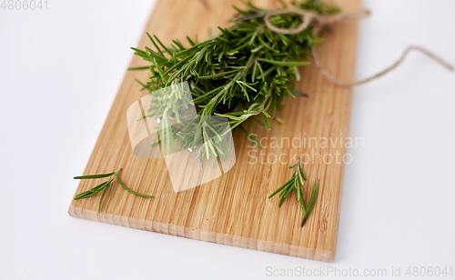 Image of bunch of rosemary on wooden cutting board