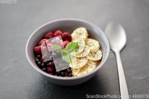 Image of cereal breakfast with berries, banana and spoon