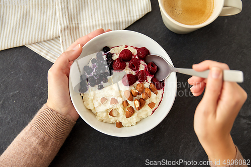 Image of hands with porridge breakfast and cup of coffee