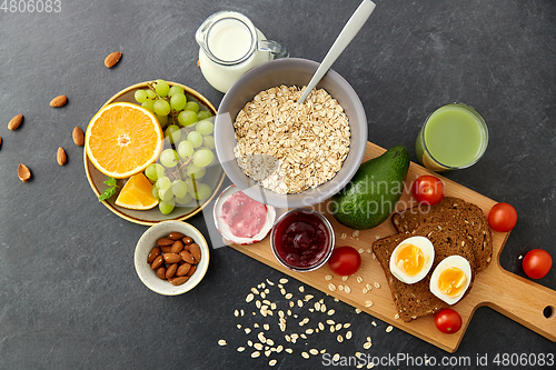 Image of oatmeal, fruits, toast bread, egg, jam and milk