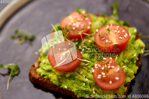 Image of toast bread with mashed avocado and cherry tomato