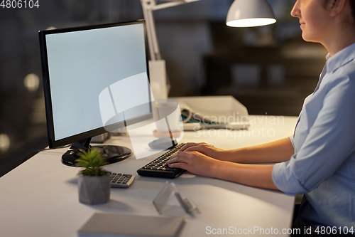 Image of businesswoman working on computer at night office