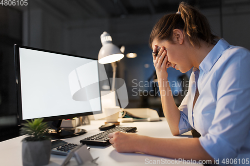 Image of sad businesswoman with computer at night office