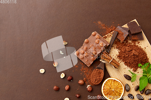 Image of chocolate with hazelnuts, cocoa beans and powder