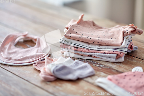 Image of baby clothes on wooden table at home