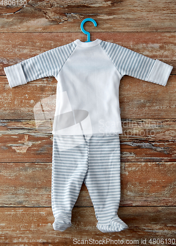 Image of baby clothes set with hanger on wooden table