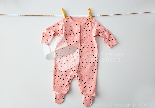 Image of bodysuit for baby girl hanging on rope with pins