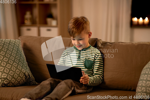 Image of happy little boy with tablet computer at home