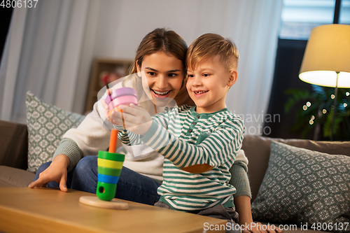 Image of mother and son playing with toy pyramid at home