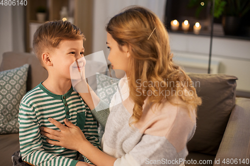 Image of happy smiling mother talking to her son at home