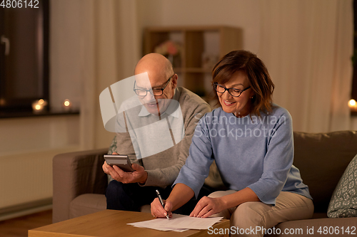 Image of senior couple with papers and calculator at home