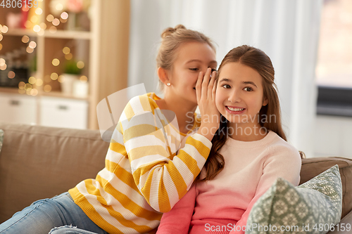 Image of happy teenage girls gossiping at home