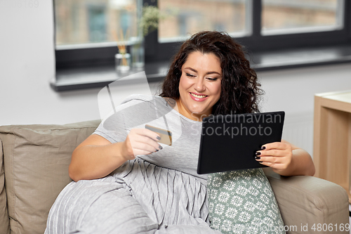 Image of woman with tablet pc and credit card at home