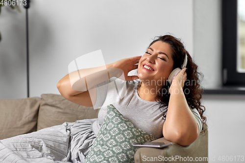 Image of woman in headphones listening to music at home