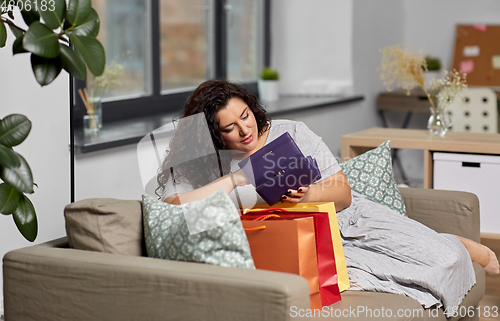 Image of woman with shopping bags and wallet at home