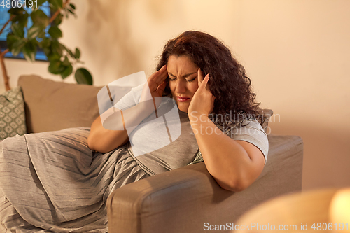 Image of woman suffering from headache at home