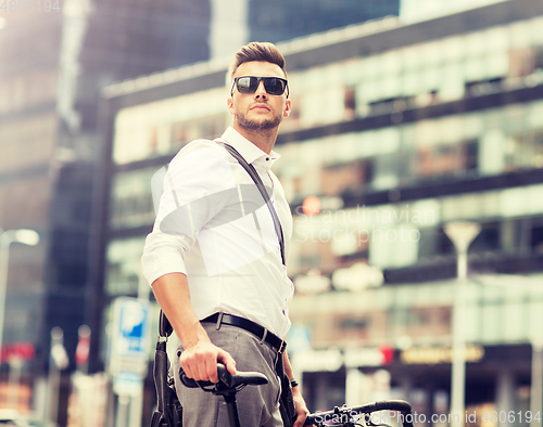 Image of young man with bicycle on city street