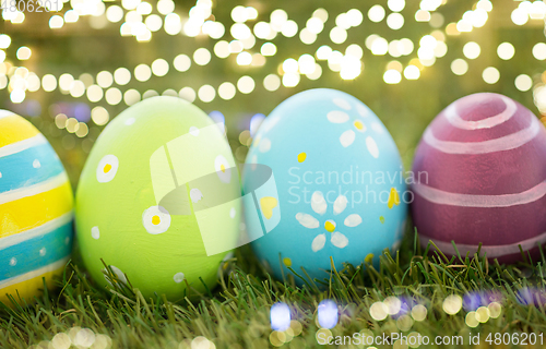 Image of row of colored easter eggs on artificial grass