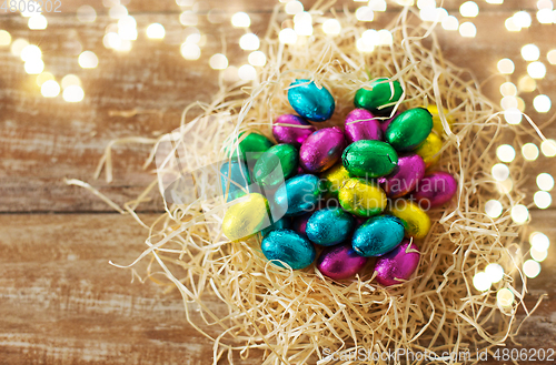 Image of chocolate eggs in foil wrappers in straw nest