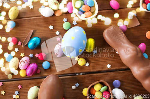 Image of chocolate eggs, easter bunny and candies on wood