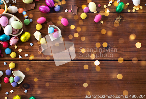 Image of chocolate eggs and candy drops on wooden table