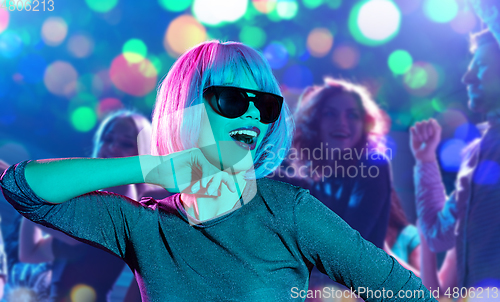 Image of woman in pink wig and sunglasses dancing at party