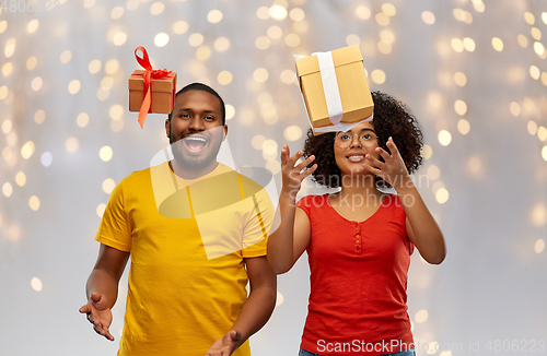 Image of happy african american couple throwing gift boxes