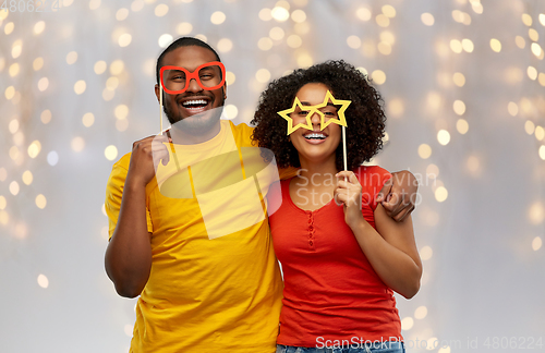 Image of happy african american couple with party props
