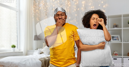 Image of sleepy african american couple over bedroom