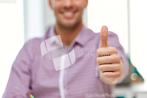 Image of happy young man showing thumbs up