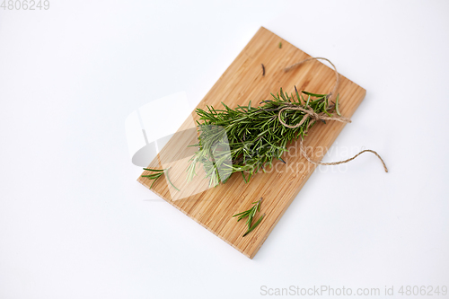 Image of bunch of rosemary on wooden cutting board