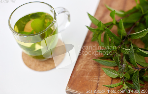 Image of herbal tea with fresh peppermint on wooden board