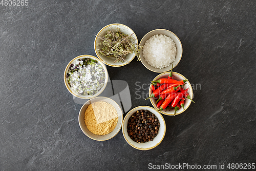 Image of bowls with different spices on slate stone table