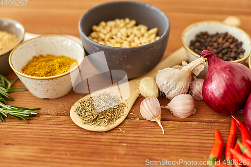 Image of spices, onion, garlic, pine nuts and chili peppers