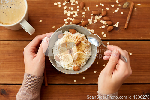 Image of hands with oatmeal breakfast and cup of coffee