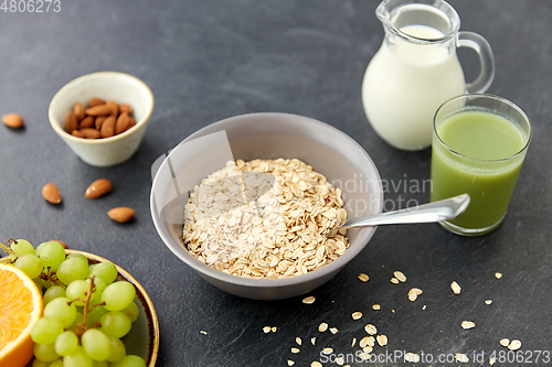 Image of oatmeal with fruits, almond nuts and jug of milk
