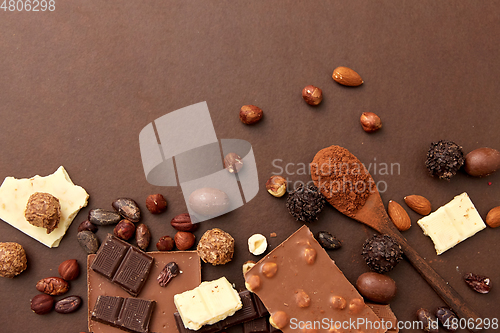 Image of chocolate with nuts, cocoa beans and powder