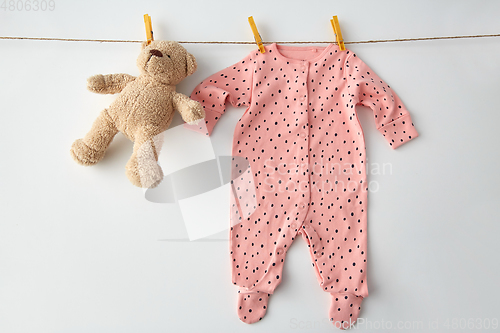 Image of bodysuit for baby girl hanging on rope with teddy