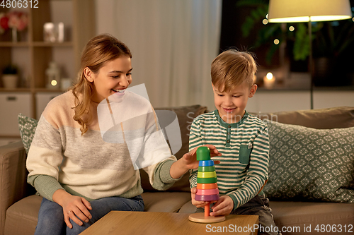 Image of mother and son playing with toy pyramid at home