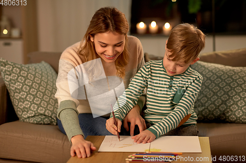 Image of mother and son with pencils drawing at home