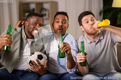 Image of friends or soccer fans with ball and beer at home