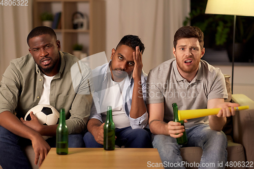 Image of sad male friends or soccer fans with beer at home