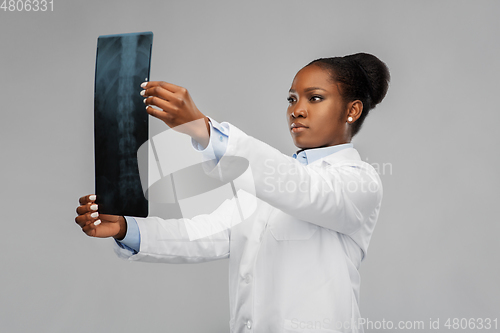 Image of african american female doctor looking at x-ray