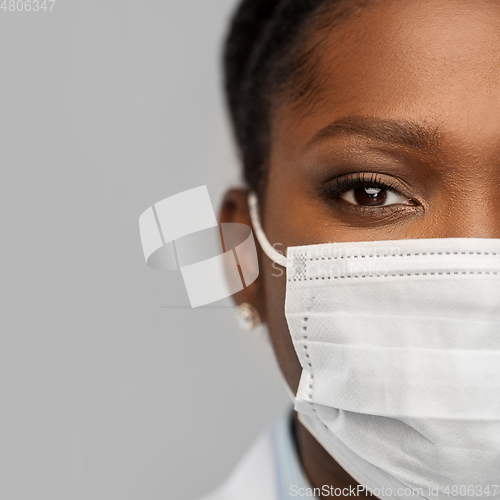 Image of african american female doctor in facial mask
