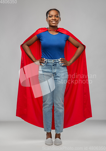 Image of happy african american woman in red superhero cape