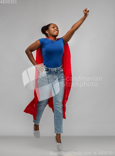 Image of happy african american woman in red superhero cape