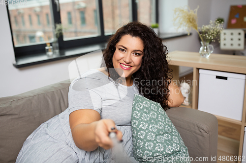 Image of happy woman taking selfie at home